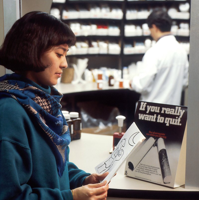Woman reading 'stop smoking' leaflet