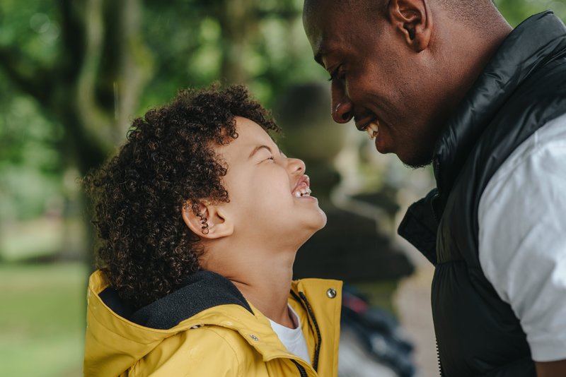 Father and son smiling at one another